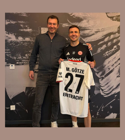 Tim Stracke und Mario Götze stehen nebeneinander, Mario Götze hält ein Trikot mit der Nummer 27